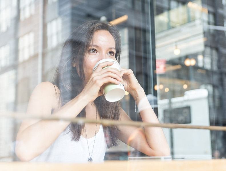 femme buvant un cafe fenetre